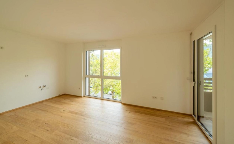 Zimmer mit bodentiefem Fenster und Blick ins Grüne, Wohnanlage Janzgasse.